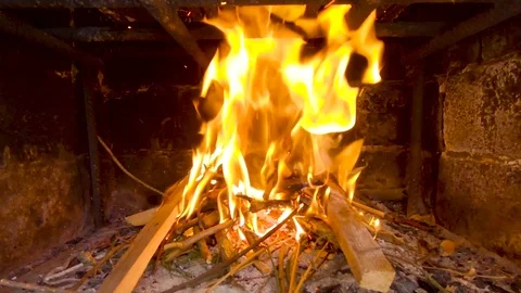 Close-up view of fire burning in an outdoor fireplace flying out of it sparks Stock Footage 107822932