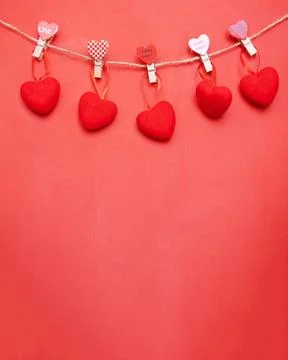 Close up view of five red hearts cut from paper and held by small clothe pegs on Stock Photos