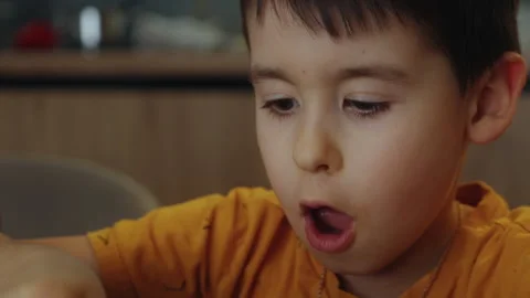 Close up view of a five-year-old boy playing with slime while sitting at a table Stock Footage 263919740