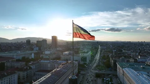 A close-up view of the flag of Bulgaria blowing in the wind against a sunset Stock Footage 324848126