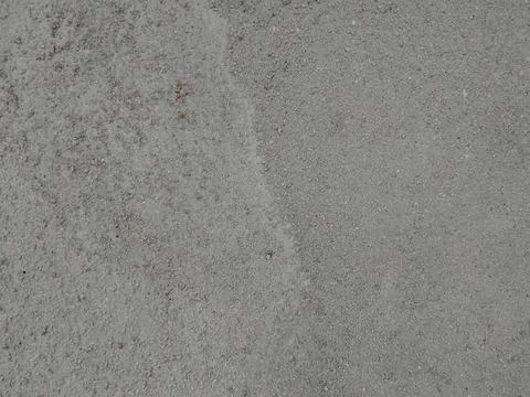 A close up view of a flat, light gray concrete surface displaying a fine, s.. Fotos Stock