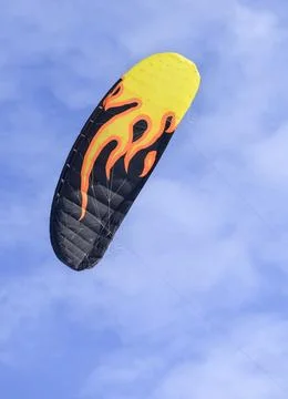 A close-up view of a flying colored parachute for snowkiting in the bright sky Stock Photos