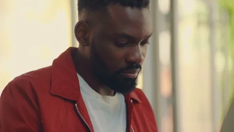 Close up view of focused busy young Afro-American man in stylish red jacket Stock Footage 111220813