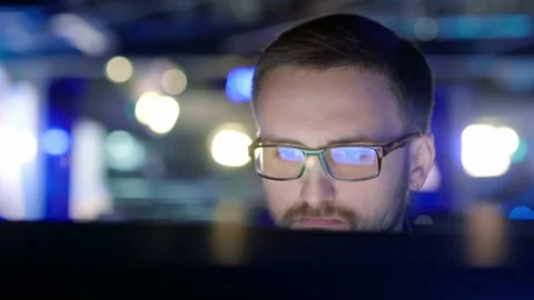 Close up view of a focused man with glasses in front of a computer. Stock Footage 198057817