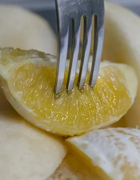 Close up view of fork picking up slice of orange Stock Photos