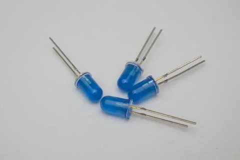 Close-up view of four blue LED (Light Emitting Diode) components on a gray Stock Photos