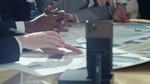 Close-up view of four Caucasian office workers in suits sitting at negotiating Stock Footage 189033698