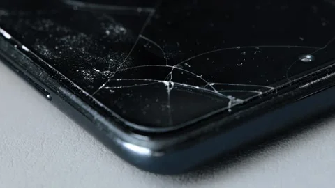 Close up view of fractured screen protector over dark color smartphone Video stock 344095108