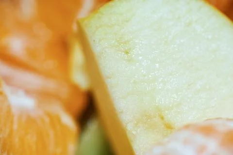 Close-up view of fresh apple slice and mandarin segments in a fruit salad Stock Photos