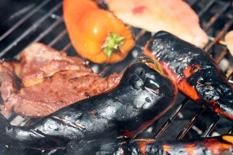 Close-up view of fresh bell peppers and meat grilling on a hot barbecue grate Stock Photos