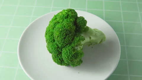 Close-up view of fresh broccoli. Green cabbage on white plate Stock Footage 276300957