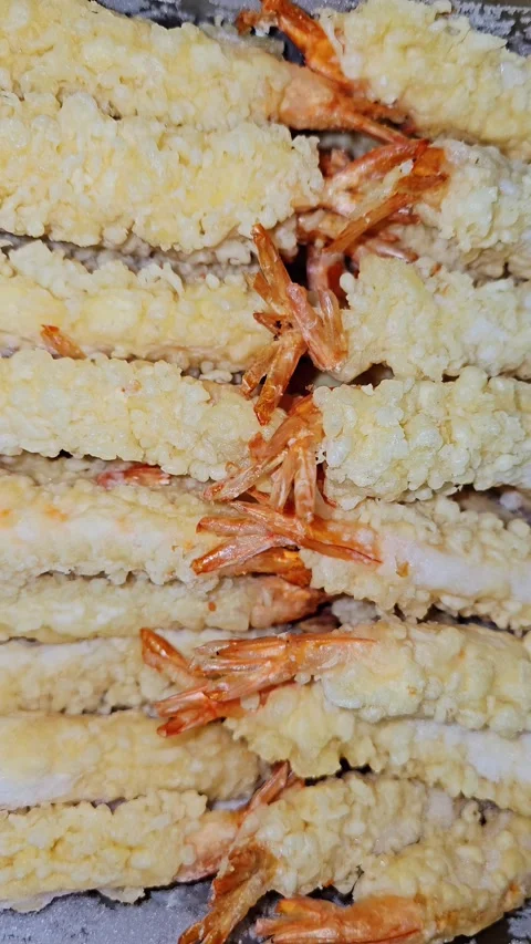 A close-up view of fresh, crispy shrimp tempura neatly arranged in rows Video stock 340169983