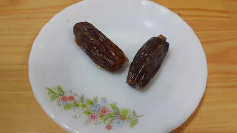 Close up view of fresh dried date palm served in ceramic small white plate Foto stock