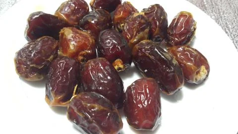 Close up view of fresh dried date palm served in ceramic small white plate Stock Photos
