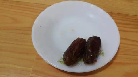 Close up view of fresh dried date palm served in ceramic small white plate Foto stock