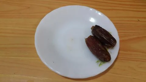 Close up view of fresh dried date palm served in ceramic small white plate Foto stock