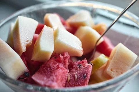 Close-up view of fresh mixed fruit salad served in a clear glass bowl Stock Photos