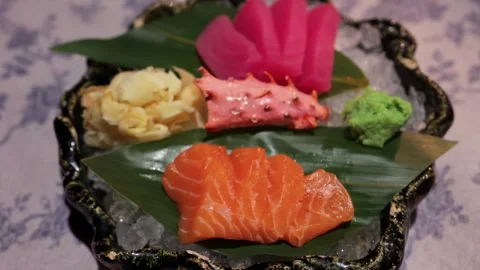 A close-up view of fresh salmon sashimi slices, wasabi, ginger, and sea cuc.. Stock Footage 339258002