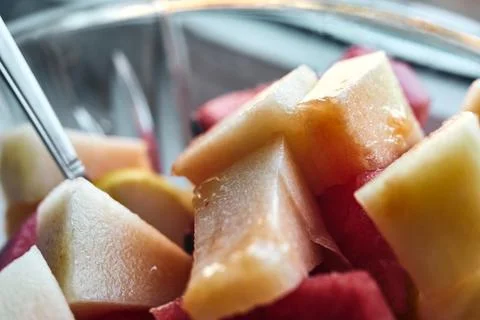 Close-up view of fresh sliced melon and watermelon chunks inside a glass bowl Stock Photos