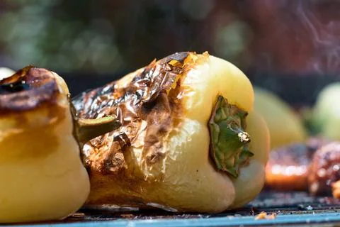 Close-up view of fresh yellow bell peppers grilling over hot charcoal on ba.. Stock Photos