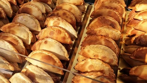 A close-up view of freshly baked empanadas with golden-brown crusts arrange.. Stock Footage 325666874