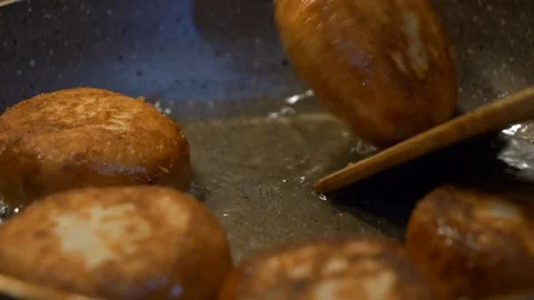 Close-Up View of Fried Donuts Being Picked From Boiling Pan with fork and spoon Vidéo 264916345