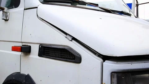Close up view of front side of old white commercial van with slightly open hood Stock Footage 325699121