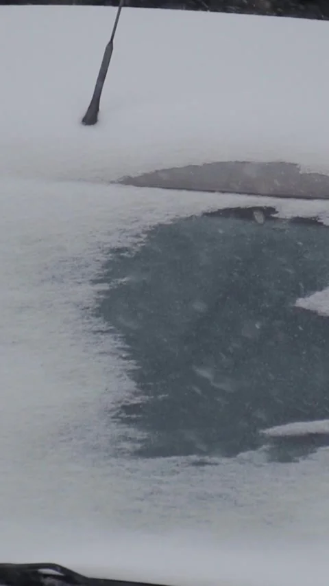 Close view of frozen vehicle windshield collecting snowfall during severe winter Stock Footage 346639998