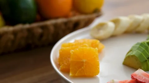 Close-up view of fruit plate rotating clockwise next to fruit basket Stock Footage 272290907