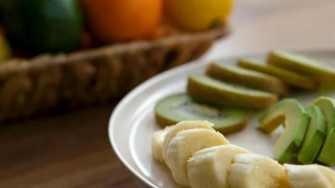 Close-up view of fruit plate rotating counterclockwise next to fruit basket Stock Footage 272293181