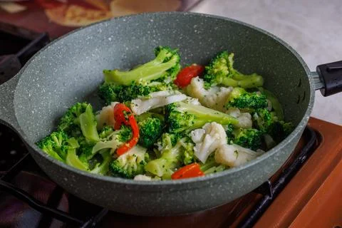 Close-up view of frying vegetables in pan without lid Фото