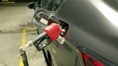 Close Up View of Fuel Nozzle Refueling Car at Gas Station with Open Fuel Door Stock Footage 343971311