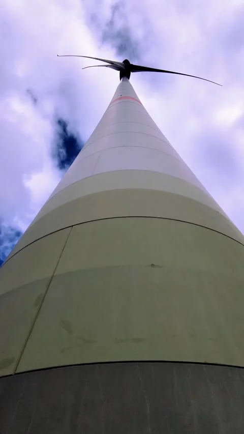 Close up view of a full height wind turbine spinning against the sky. Stock Footage 317579271