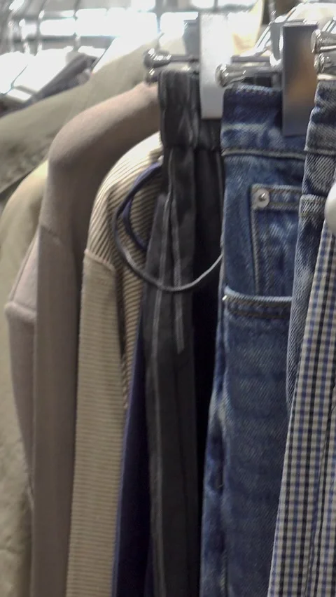 Close view of garments on a clothing rack in a fashion store interior Stock Footage 347679986