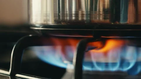 Close up view of a gas range heating up a stainless steal pot Stock Footage 276720200