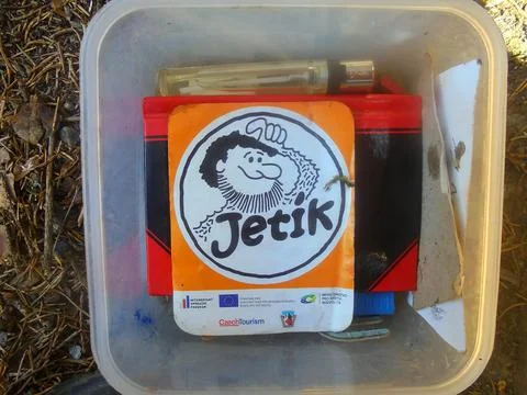 Close view of geocache container with several small things inside. Stock Photos