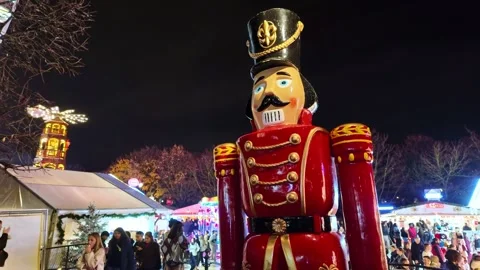 Close-up view of a giant nutcracker statue towering above a festive outdoor Stock Footage 322736958