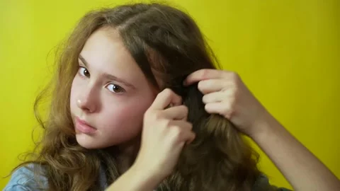 Close-up view of girl looking to the camera while touching her curly hair Stock Footage 235622150