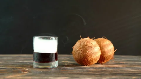 Close up view of glass and coconuts on wooden table and dark background. Stock Footage 207473694