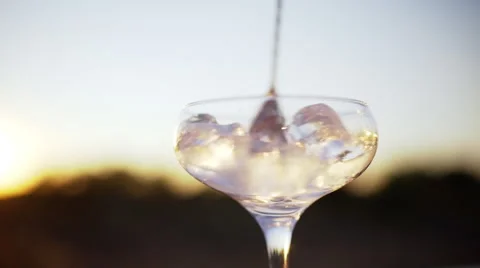Close up view of glass with ice sunset background Slow motion Stock Footage 68922744