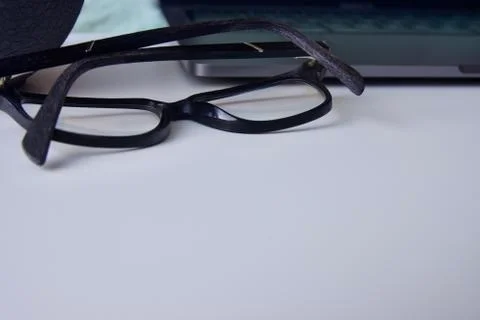 Close view of the glasses placed on the work desk next to the laptop Stock Photos