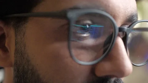 Close-up view of glasses with reflection of binary code on computer. Young 库存影片 228859271