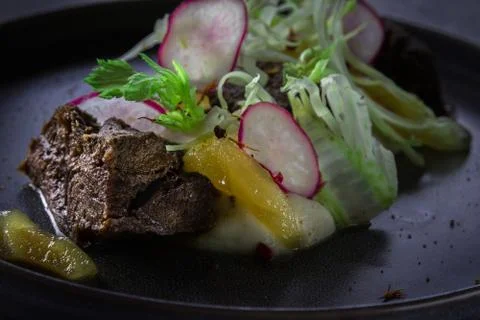 Close up view on Glazed Beef Cheek with celery puree and ginger pear on gray Photos