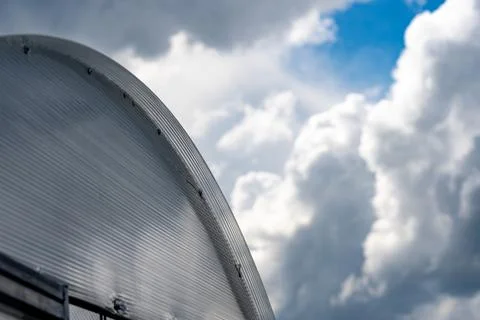 Close-Up View of a Glossy Circular Structure Against a Dramatic Sky with Stock Photos