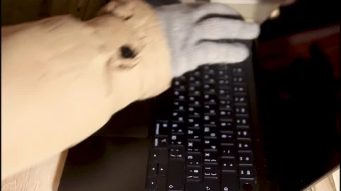 Close up view gloved hands working on a laptop keybaoard at home, power outage Stock Footage 328063035