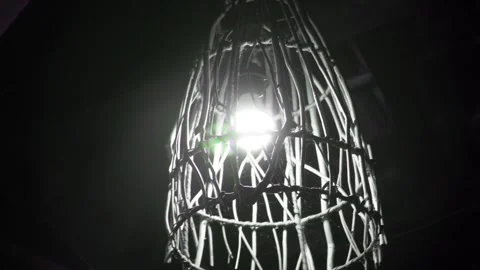 Close up view of a glowing bright electric light bulb inside a rustic wooden Video stock 337870719