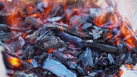 Close view at a glowing charcoal and flame in the barbecue grill. Video stock 82472630