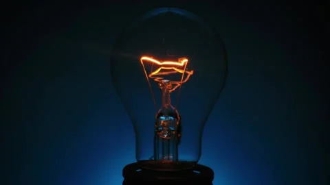 Close up View of Glowing Light Bulb on Blue Background 스톡 동영상 329766610