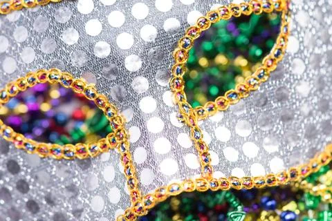 Close up view of gold and silver sequined Mardi Gras mask with colorful beads ou Stock Photos