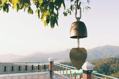 Close up view of golden bell in temple with mountain background. Stock Photos
